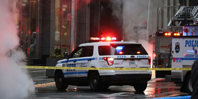 NYPD police car and other emergency vehicles behind police tape and surrounded with smoke